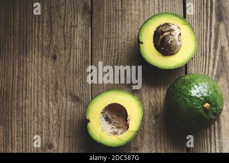 Avocado Obst und Scheiben schneiden Hälften Avocado auf Holzhintergrund, Früchte gesunde Ernährung Konzept. Stockfoto