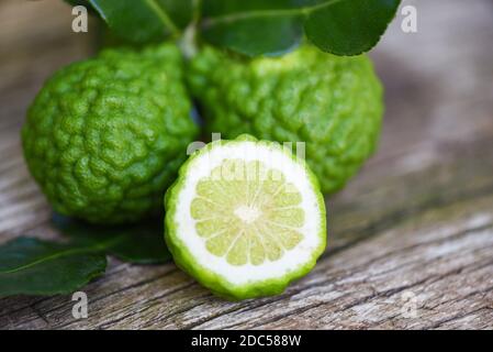 Frische Bergamotte Früchte, Kaffir Lime, Citrus Bergmia mit Blatt auf Holztisch / Slice Bergamotte Zitrusfrüchte ätherisches Öl Konzept Stockfoto