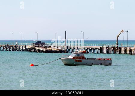 Ein Fischerboot mit selektivem Fokus und der beachport Steg Im Hintergrund im beachport South australia am november 2020 Stockfoto