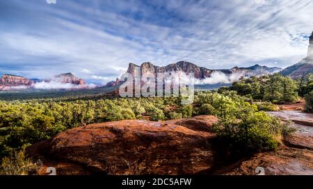 Niedrige Wolke hängt um die Red Rocks von Munds Mountain und Twin Buttes nach einem starken Regen in der Nähe der Stadt Sedona im Norden von Arizona, USA Stockfoto