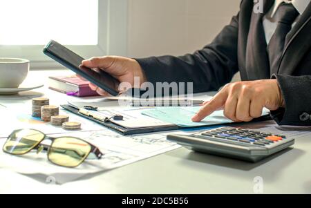 Männliche Buchhalter arbeiten an Finanzdokumenten und Kalkulatoren für Geschäfts- und Finanzausgaben. Stockfoto