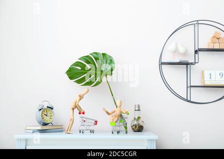 Kommode mit hölzernen Schaufensterpuppen und Einkaufswagen Innenraum des Zimmers Stockfoto