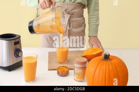 Frau bereitet leckere Kürbis Smoothie am Tisch Stockfoto