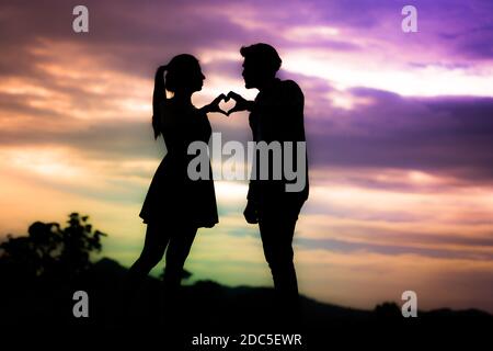 Silhouette Bild des Paares macht Herzform mit der Hand Stockfoto