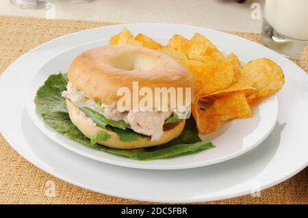 Ein Thunfisch-Sandwich auf einem Bagel mit Grill gewürzt Kartoffelchips Stockfoto