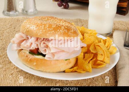 Ein Schinken-Sandwich auf einem Bagel mit Maischips Stockfoto