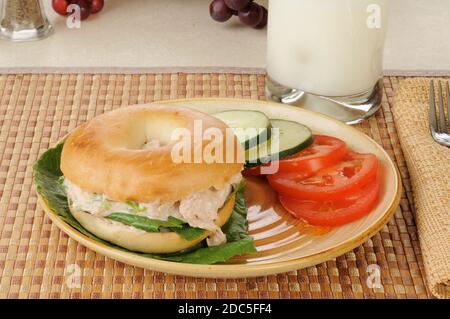 Ein tunafisches Sandwich auf einem Bagel mit Tomatenscheiben und Gurke Stockfoto