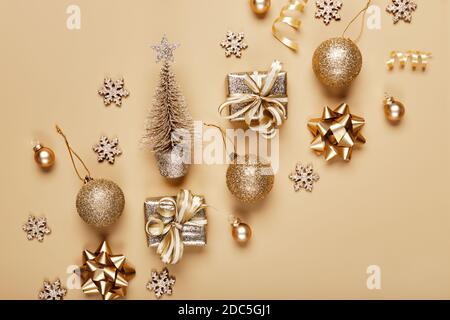 Goldene weihnachtsdekoration und Kugel auf beigefarbenem Hintergrund. Kreatives Layout in neutralen Schwarzweiß-Farben Stockfoto