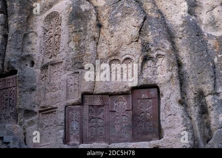 Khachkars, Gedenkstelen mit armenischen Kreuzen, die auf der Klippe des mittelalterlichen Klosters Geghard, das im 4. Jahrhundert von Gregor dem Erleuchter in der armenischen Provinz Kotayk gegründet wurde, geschnitzt wurden Stockfoto