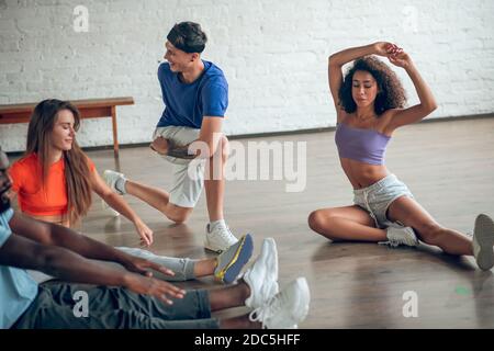 Gruppe von Tänzern, die sich vor der Probe aufwärmen Stockfoto