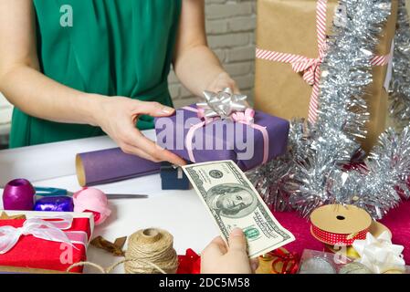 Zahlung für Geschenkverpackung bei der Verpackung mit USA-Dollar-Banknoten. Stockfoto