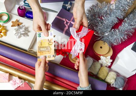 Zahlung für Geschenkverpackung bei der Verpackung mit Euro-Banknoten. Stockfoto