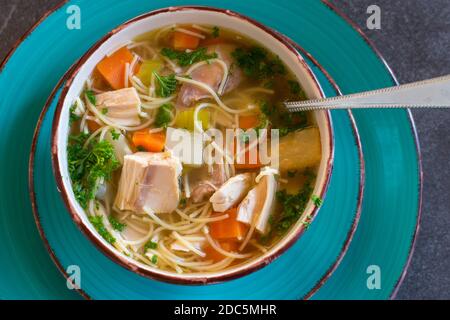 Eine Schüssel Hühnersuppe mit Nudeln von oben Stockfoto