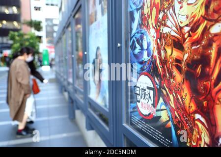 Am 18. November 2020 laufen die Menschen an einem Plakat für einen Animationsfilm vorbei, der auf dem beliebten japanischen Manga 'Demon Slayer: Kimetsu no Yaiba The Movie: Infinite Train' basiert. Quelle: Naoki Nishimura/AFLO/Alamy Live News Stockfoto