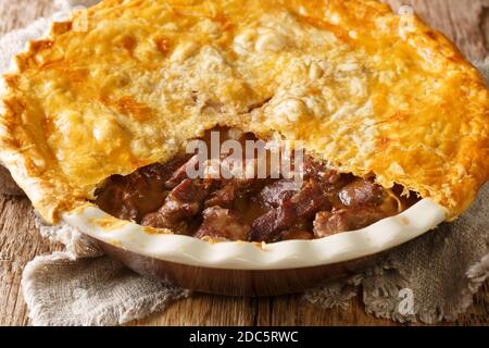 English Beef Steak Pie mit knusprigen Blätterteig close-up in einer Auflaufform auf dem Tisch. Horizontal Stockfoto