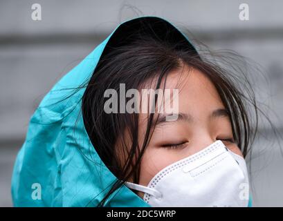 Peking, Neuseeland. März 2020. Ein Mädchen mit Gesichtsmaske trotzt dem Wind in Wellington, Neuseeland, 17. März 2020. Kredit: Guo Lei/Xinhua/Alamy Live Nachrichten Stockfoto