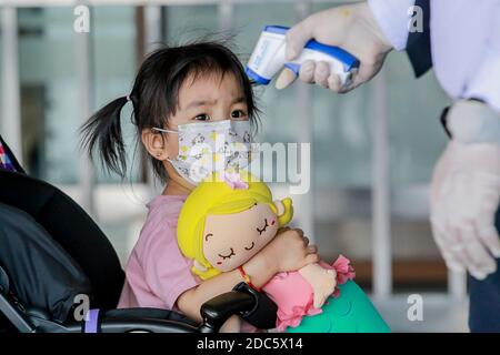 Peking, China. März 2020. Ein Mädchen, das eine Gesichtsmaske trägt, lässt sich bei ihrer Ankunft am internationalen Flughafen Ninoy Aquino (NAIA) in Pasay City, Philippinen, am 27. März 2020 auf ihre Temperatur überprüfen. Quelle: Rouelle Umali/Xinhua/Alamy Live News Stockfoto