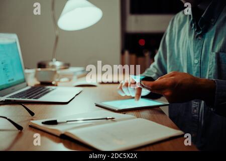 Kaukasischer Geschäftsmann, der Finanzen mit Kreditkarte sortiert Auf dem Handy Stockfoto