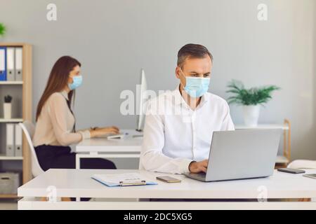 Bewusste Mitarbeiter tragen Masken, um ihre Kunden zu schützen und die Ausbreitung von COVID-19 zu verhindern. Stockfoto