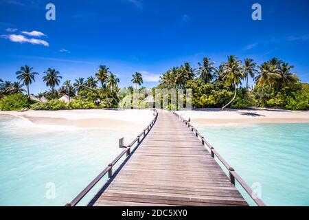 Malediven Strandresort Panoramalandschaft. Tropischer Urlaub am Strand. Langer hölzerner Pier, Steg in die paradiesische Insel, Palmen, weißer Sand, blauer Himmel Stockfoto