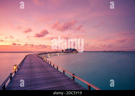 Sonnenuntergang auf den Malediven, Luxus-Wasservillen-Resort und hölzerner Pier. Schöne Himmel Wolken und Strand Natur Hintergrund für Sommerferien Stockfoto