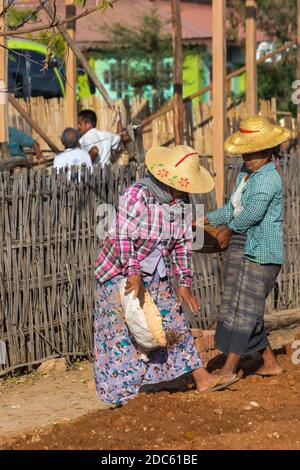 Dorfbewohner Unternehmen manuelle Straßenbauarbeiten in West Phwar Saw Village, Bagan, Myanmar (Burma), Asien im Februar, Frauen bewegen Entleerungsmaterialien Stockfoto