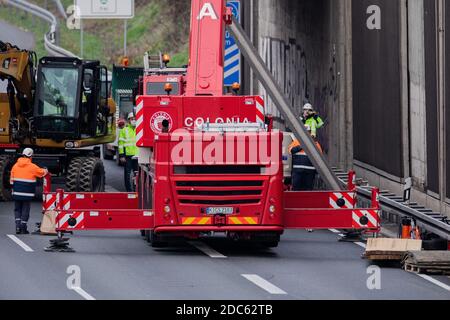 Köln, Deutschland. November 2020. Arbeiter und Polizei entfernen mit einem Kran eine erste Betonplatte auf der A3. Kaum eine Woche, nachdem eine Betonplatte auf dem A3 auf das Auto einer 66-jährigen Kölnerin gefallen ist, werden jetzt sechs weitere entfernt. Auch sie könnten potenziell gefährlich sein. Weil diese Platten auch falsch fixiert wurden. Quelle: Rolf Vennenbernd/dpa/Alamy Live News Stockfoto