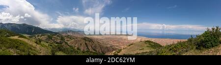 Panorama des Issyk-Kul-Sees bei Ottuk und Barbulak in Kirgisistan an einem Sommertag mit blauem Himmel. Stockfoto