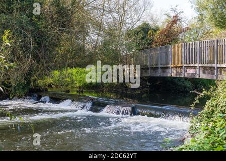 Wehr und Fußgängerbrücke auf dem Fluss Colne, Stockers Lake nature reseerve, Rickmansworth, Hertfordshire, England, Großbritannien Stockfoto