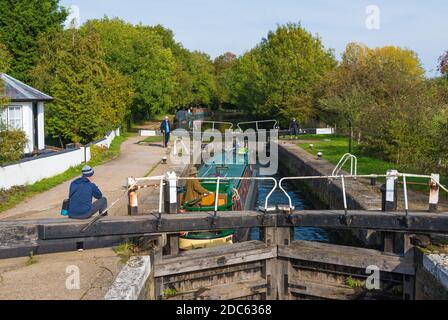 Ein schmales Boot, das die Schleuse bei Stockers Lock, Grand Union Canal, Rickmansworth, Hertfordshire, England, Großbritannien, überfährt Stockfoto