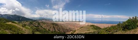 Panorama des Issyk-Kul-Sees bei Ottuk und Barbulak in Kirgisistan an einem Sommertag mit blauem Himmel. Stockfoto