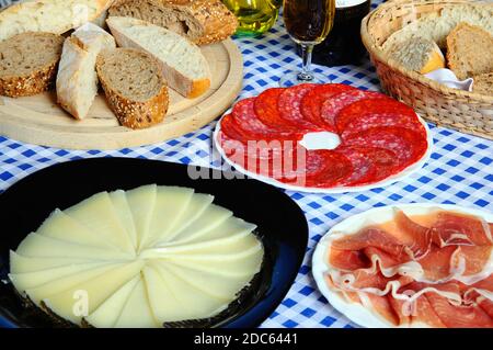 Eine Auswahl an spanischen Tapas, darunter Manchego-Käse, Serrano-Schinken und Salami, Calahonda, Spanien. Stockfoto