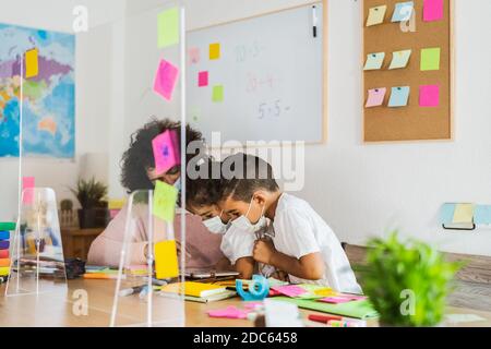 Lehrer mit Kindern tragen Gesichtsmaske in der Vorschule Klassenzimmer während corona-Virus-Pandemie - schulische Maßnahmen für Bildung und Sicherheit Stockfoto