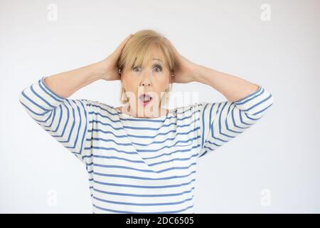 Überrascht, ältere Dame isoliert. Weibchen mit den Händen auf Gesicht. Sehen Sie das unglaubliche. Stockfoto