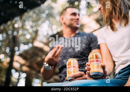 Schönes junges Paar sitzen Bier trinken und feiern Stockfoto