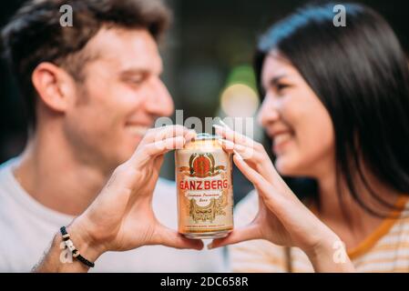 Bier-Party - Junges Paar genießen heißen Sommertag auf einer Dachparty, trinken Ganzberg Bier und Spaß haben Stockfoto