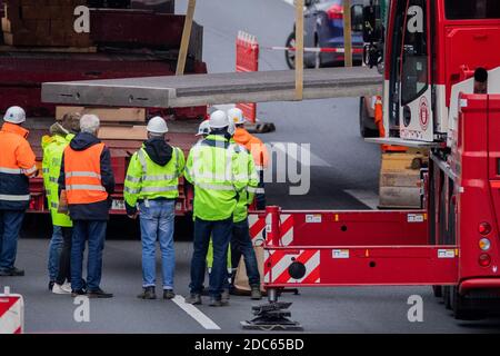 19. November 2020, Nordrhein-Westfalen, Köln: Eine erste Betonplatte wird mit einem Kran auf einen Tieflader der A3 gestellt. Kaum eine Woche, nachdem eine Betonplatte auf dem A3 auf das Auto einer 66-jährigen Kölnerin gefallen ist, werden jetzt sechs weitere entfernt. Auch sie könnten potenziell gefährlich sein. Weil diese Platten auch falsch fixiert wurden. Foto: Rolf Vennenbernd/dpa Stockfoto