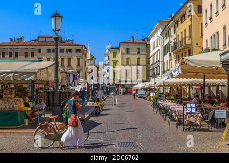 Marktstände, Cafés und Dame auf Handy mit Fahrrad in Piazza della Frutta, Padua, Venetien, Italien Stockfoto