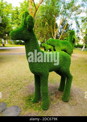 Skulptur eines Hirsches im Profil in einem grünen Park vor einem Hintergrund von Bäumen. Stockfoto