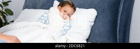 Krankes, trauriges Mädchen im warmen Schal, das zu Hause im Bett liegt, Banner Stockfoto