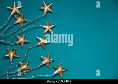 Draufsicht auf sternförmige Weihnachtslichter vor grünem Hintergrund Mit Kopierbereich Stockfoto