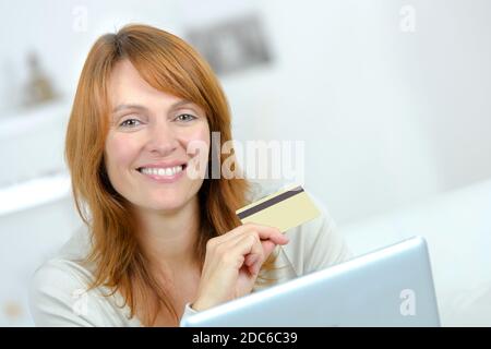 Lächelnde Frau mit Kreditkarte Stockfoto