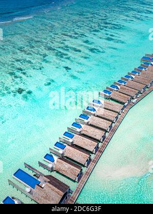 Landschaft mit Holzhotel am Meer, azurblauem Wasser, Sandstrand, grünen Bäumen, Boot. Luxus Resort Luftaufnahme, Küste, Küste des Riffs, erstaunliche Aussicht Stockfoto