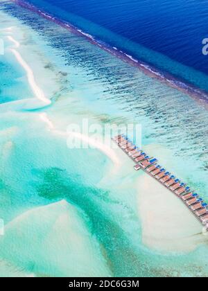 Landschaft mit Holzhotel am Meer, azurblauem Wasser, Sandstrand, grünen Bäumen, Boot. Luxus Resort Luftaufnahme, Küste, Küste des Riffs, erstaunliche Aussicht Stockfoto