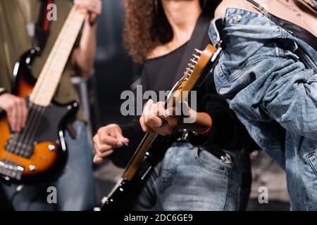KIEW, UKRAINE - 25. AUGUST 2020: Beschnittene Ansicht des Rockband-Musikers mit verschwommenen Gitarristen im Hintergrund Stockfoto