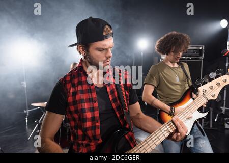 KIEW, UKRAINE - 25. AUGUST 2020: Musiker spielen E-Gitarren mit Hintergrundbeleuchtung auf verschwommenem Hintergrund Stockfoto