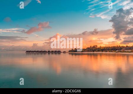 Luxuriöses Strandresort. Wasservillen an der Küste der Insel, tropische Bucht Lagune. Meer Reflexion, friedliche Sonnenuntergang Sonnenaufgangslandschaft. Paradiesische Natur Stockfoto