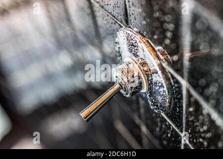 Nahaufnahme der modernen schwarzen Dusche Badewanne mit blauen Vorhängen im Badezimmer in Modell Haus, Wohnung oder Haus, Fliesen, Wasserhahn, Tropfen Wasser Stockfoto