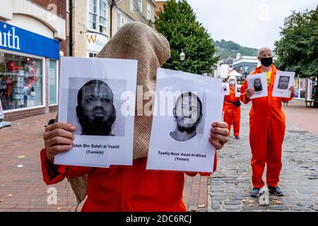 Mitglieder der Lewes Amnesty International Gruppe in Orange Jump Anzügen protestieren gegen das Guantanamo Militärstrafanstalt, Lewes, Sussex, Großbritannien. Stockfoto