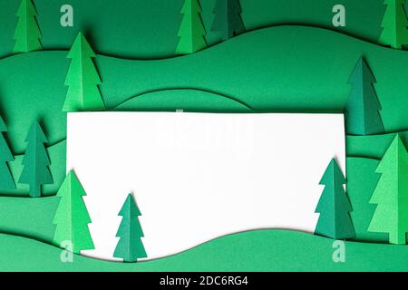 3D Pop out Weihnachtsbäume Papier Kunstwerk in grünem Hintergrund. Weihnachtsbaum Papier schneiden Design-Karte. Draufsicht. Flach liegend Stockfoto